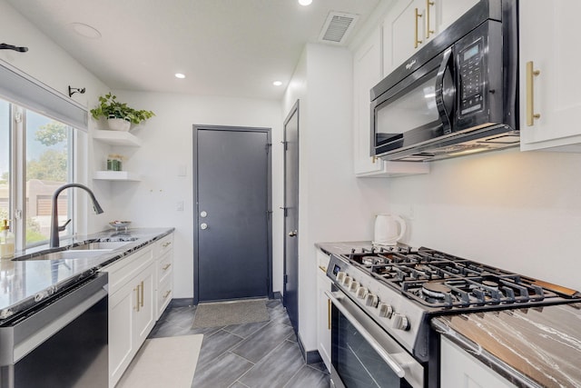 7218 Whippoorwill Ln NE, Albuquerque, NM 87109 - kitchen featuring visible vents, a sink, light stone counters, white cabinets, and stainless steel appliances