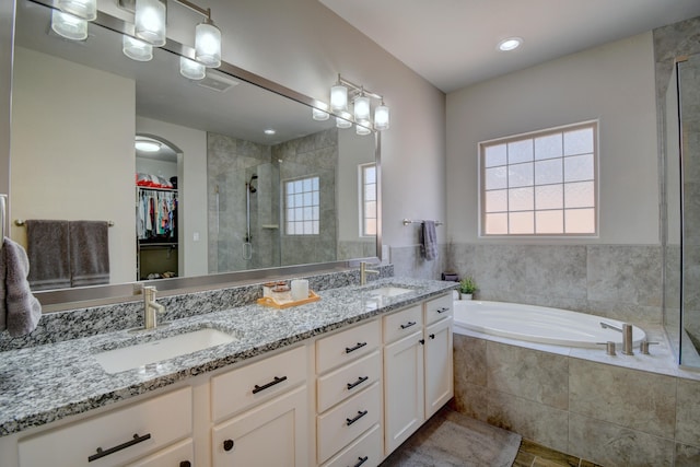 7408 Molas Rd NW, Albuquerque, NM 87114 - full bathroom featuring a stall shower, healthy amount of natural light, double vanity, and a garden tub