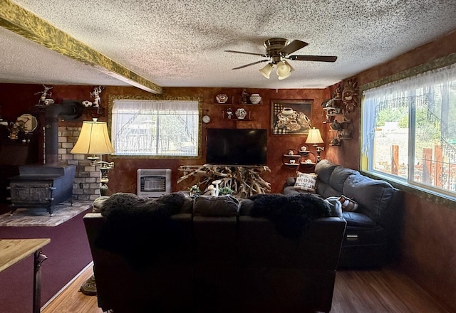 10 Cliffside Dr, Ramah, NM 87321 - living room featuring ceiling fan, a textured ceiling, a wood stove, wood finished floors, and heating unit