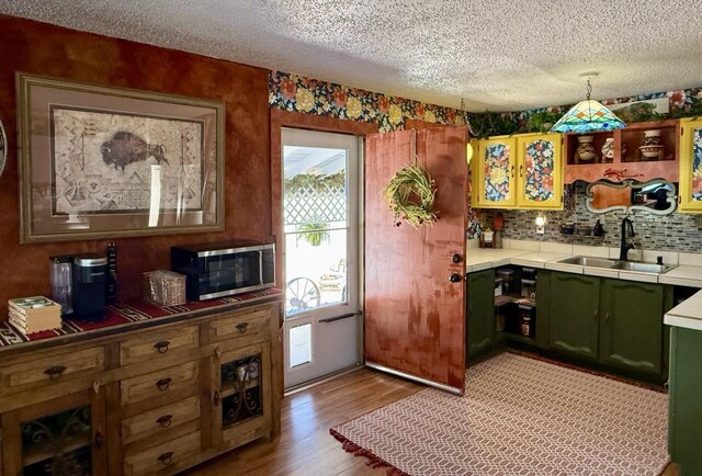 10 Cliffside Dr, Ramah, NM 87321 - kitchen featuring a textured ceiling, stainless steel microwave, a sink, and green cabinets