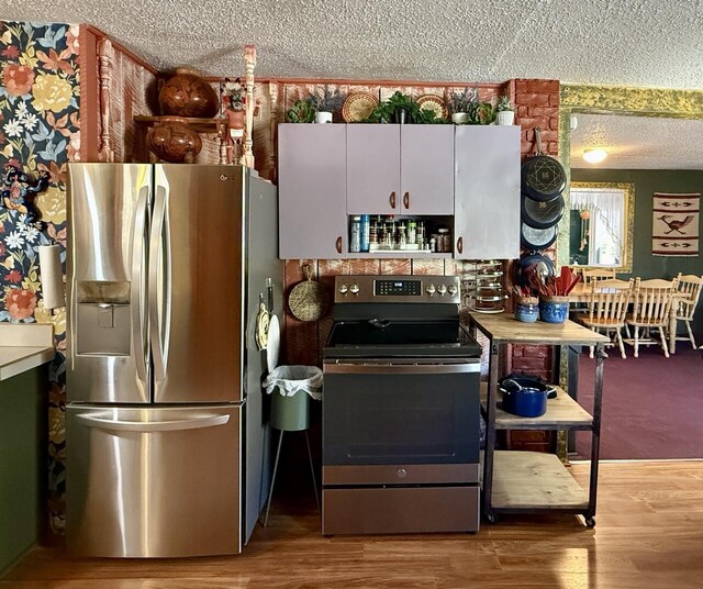 10 Cliffside Dr, Ramah, NM 87321 - kitchen with a textured ceiling, appliances with stainless steel finishes, and wood finished floors