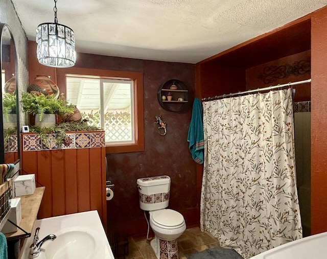 10 Cliffside Dr, Ramah, NM 87321 - full bath with an inviting chandelier, toilet, a shower with shower curtain, a textured ceiling, and a sink