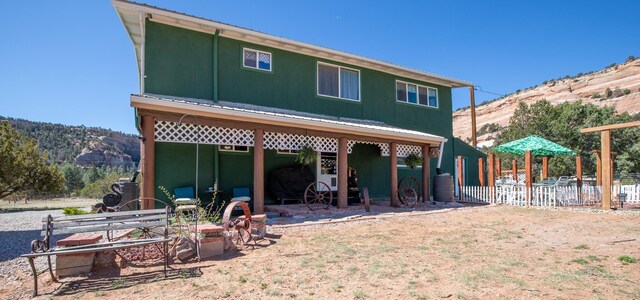 10 Cliffside Dr, Ramah, NM 87321 - back of property with stucco siding, a mountain view, and fence