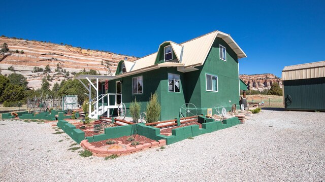 10 Cliffside Dr, Ramah, NM 87321 - view of front of home with a garden, metal roof, and stucco siding