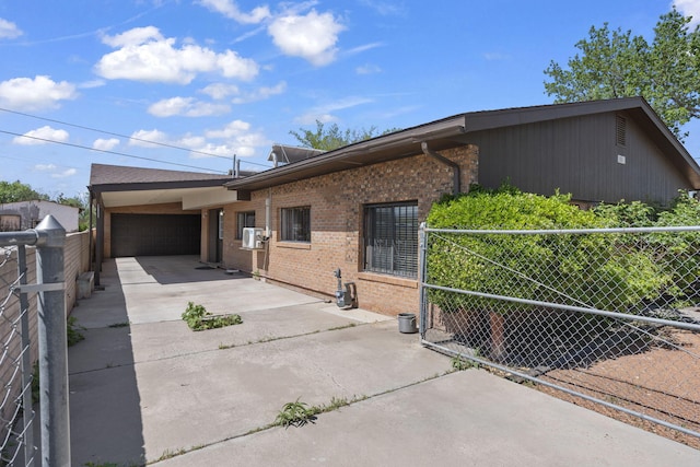 view of front of home featuring brick siding, driveway, fence, and a garage