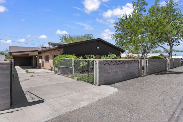 view of front facade featuring fence private yard, driveway, a gate, and a garage