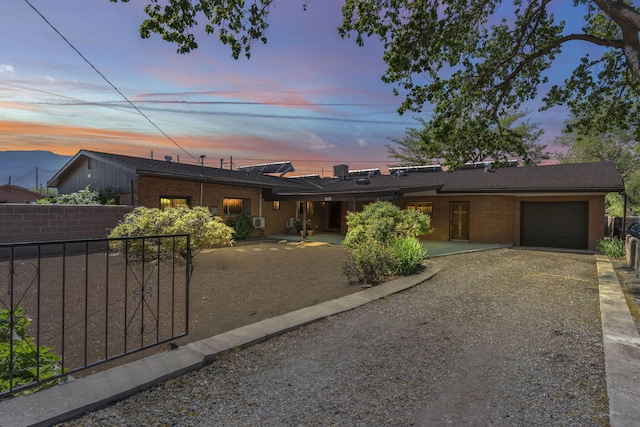 view of front facade featuring brick siding, an attached garage, and fence