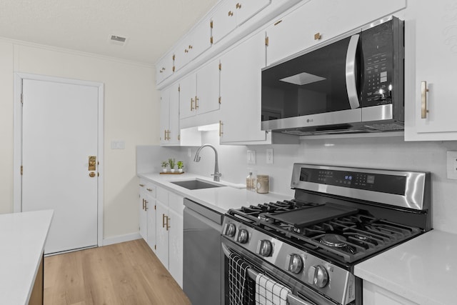 kitchen with a sink, light countertops, light wood-style floors, and stainless steel appliances