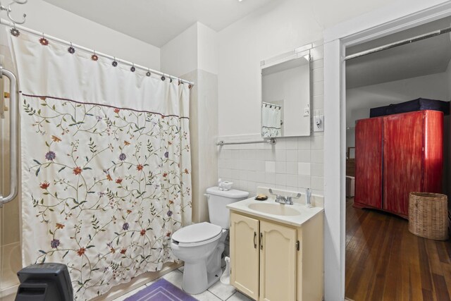 full bathroom featuring wood finished floors, toilet, curtained shower, and vanity