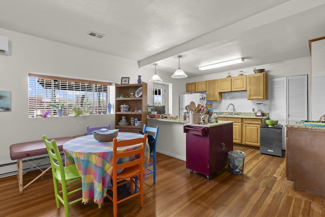 kitchen featuring visible vents, freestanding refrigerator, wood finished floors, light countertops, and a sink
