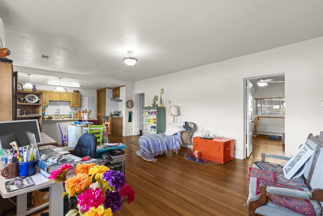 living area with a ceiling fan, wood finished floors, and visible vents