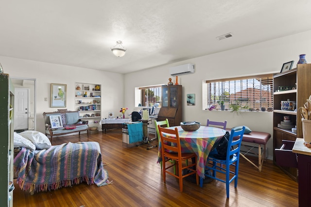 dining space with an AC wall unit, wood finished floors, and visible vents
