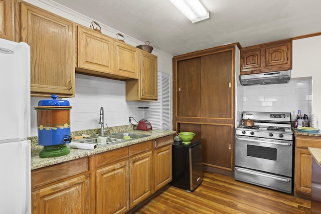 kitchen featuring a sink, gas stove, freestanding refrigerator, decorative backsplash, and under cabinet range hood