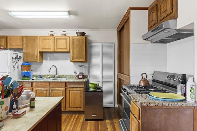 kitchen with decorative backsplash, stainless steel gas range oven, a sink, under cabinet range hood, and dark wood-type flooring