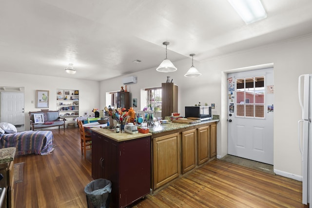 kitchen with an AC wall unit, dark wood-type flooring, stainless steel microwave, and a peninsula