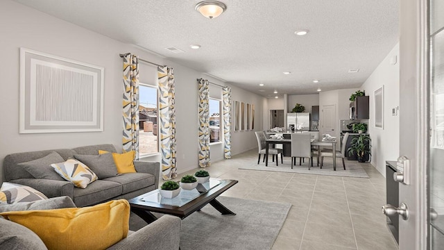living room with light tile patterned floors, recessed lighting, and a textured ceiling