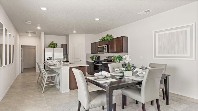 dining area featuring recessed lighting, a textured ceiling, light tile patterned flooring, and visible vents