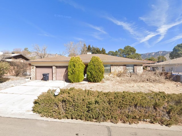 view of front of home featuring an attached garage, a mountain view, and concrete driveway