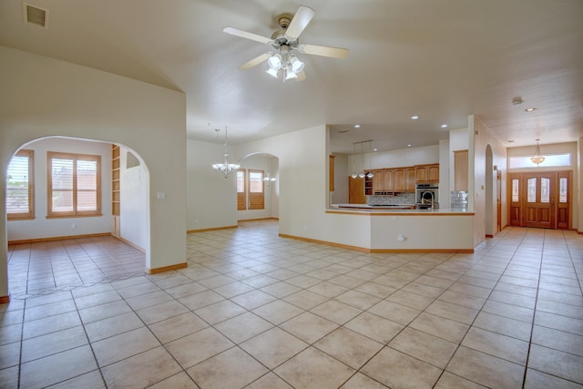 3728 Spyglass Loop SE, Rio Rancho, NM 87124 - unfurnished living room featuring recessed lighting, light tile patterned floors, baseboards, visible vents, and ceiling fan with notable chandelier