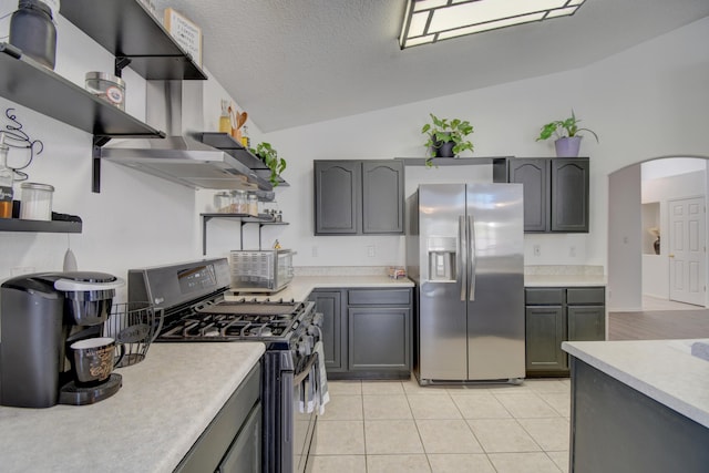 9811 Saragossa St NW, Albuquerque, NM 87114 - kitchen featuring open shelves, light countertops, arched walkways, stainless steel appliances, and lofted ceiling
