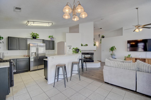 9811 Saragossa St NW, Albuquerque, NM 87114 - kitchen with a breakfast bar area, visible vents, appliances with stainless steel finishes, vaulted ceiling, and light countertops