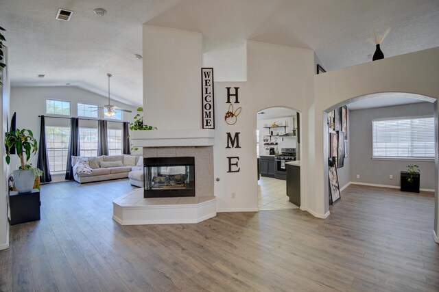 9811 Saragossa St NW, Albuquerque, NM 87114 - living area with a healthy amount of sunlight, arched walkways, ceiling fan, and lofted ceiling
