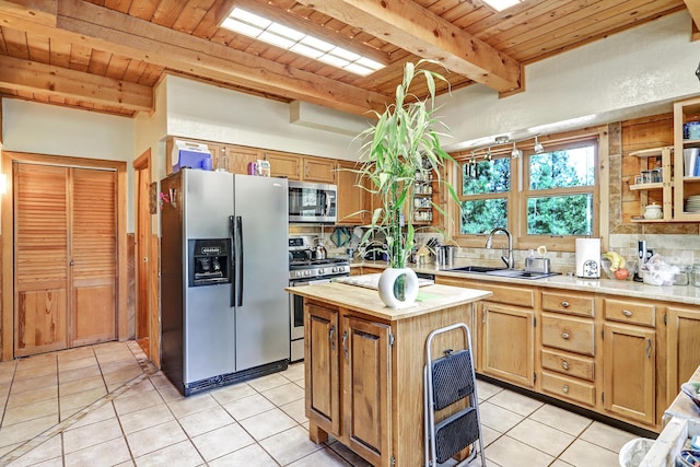 kitchen featuring appliances with stainless steel finishes, a sink, light tile patterned floors, beamed ceiling, and wood ceiling