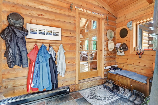 mudroom with wooden walls, vaulted ceiling, wooden ceiling, and stone finish floor