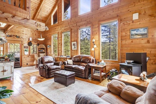 living room featuring beamed ceiling, wooden walls, high vaulted ceiling, wood ceiling, and light wood-style flooring