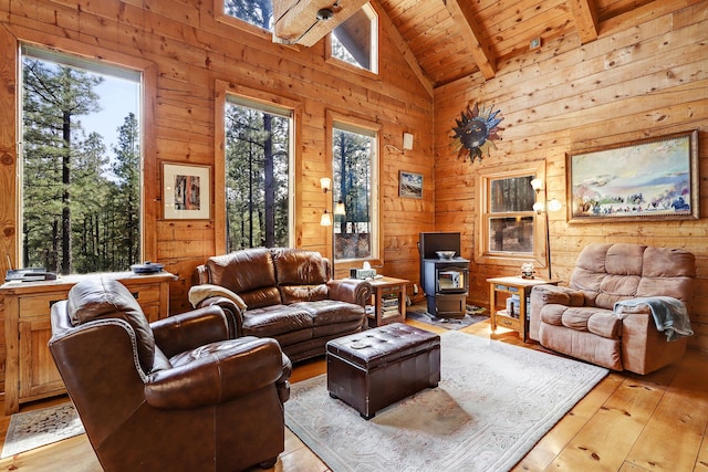 living room featuring light wood-style floors, wood ceiling, beamed ceiling, and wooden walls