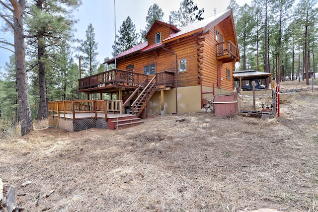 rear view of property featuring a wooden deck and log siding