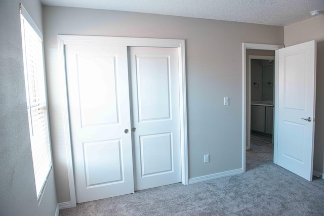 unfurnished bedroom featuring baseboards, carpet, and a closet