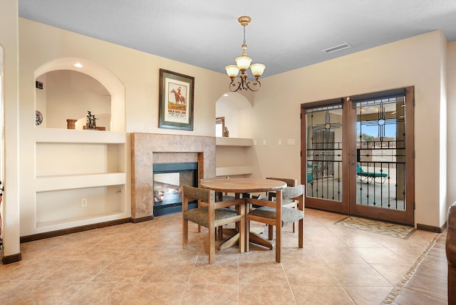 3101 Rachel Ct NE, Rio Rancho, NM 87144 - dining space featuring built in shelves, french doors, a premium fireplace, baseboards, and tile patterned flooring
