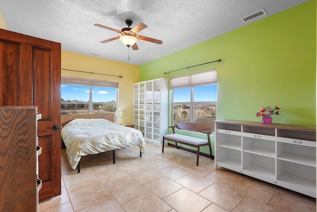 3101 Rachel Ct NE, Rio Rancho, NM 87144 - bedroom featuring multiple windows, a textured ceiling, light tile patterned flooring, and a ceiling fan