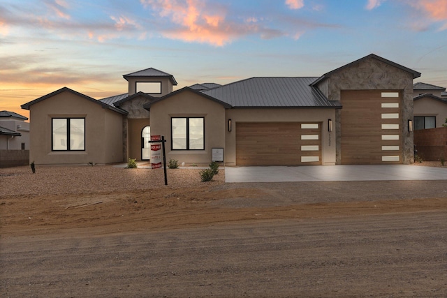 1232 21st Ave SE, Rio Rancho, NM 87124 - view of front of property featuring concrete driveway, stucco siding, a standing seam roof, metal roof, and an attached garage