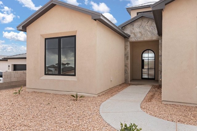 1232 21st Ave SE, Rio Rancho, NM 87124 - doorway to property with stucco siding, stone siding, and fence