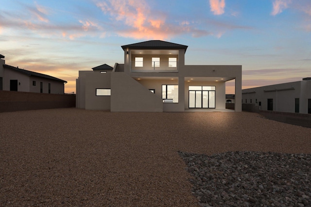1232 21st Ave SE, Rio Rancho, NM 87124 - back of property at dusk featuring fence, a patio, and stucco siding