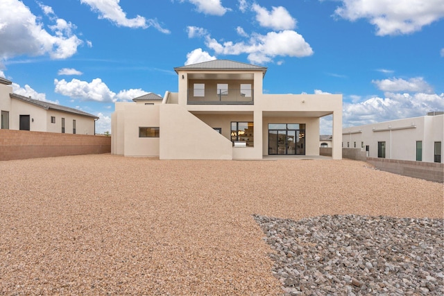 1232 21st Ave SE, Rio Rancho, NM 87124 - back of house with a fenced backyard, stucco siding, a balcony, and metal roof