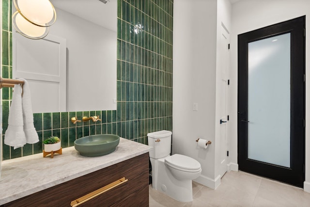 1232 21st Ave SE, Rio Rancho, NM 87124 - bathroom with tile walls, tile patterned floors, baseboards, vanity, and toilet