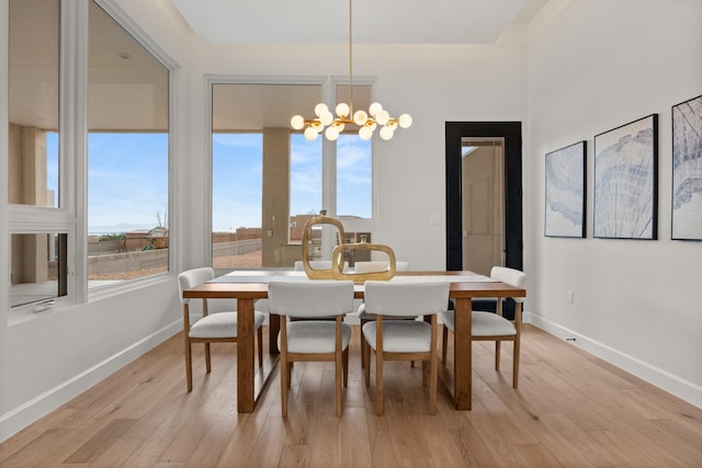 1232 21st Ave SE, Rio Rancho, NM 87124 - dining area with baseboards, light wood finished floors, a notable chandelier, and a wealth of natural light
