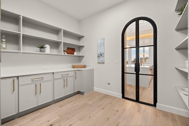 1232 21st Ave SE, Rio Rancho, NM 87124 - bar featuring light wood-style floors, baseboards, and arched walkways