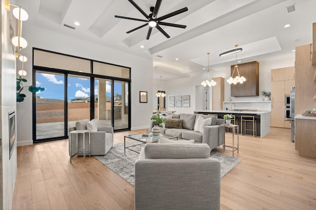 1232 21st Ave SE, Rio Rancho, NM 87124 - living area featuring visible vents, a towering ceiling, light wood-style floors, recessed lighting, and ceiling fan with notable chandelier