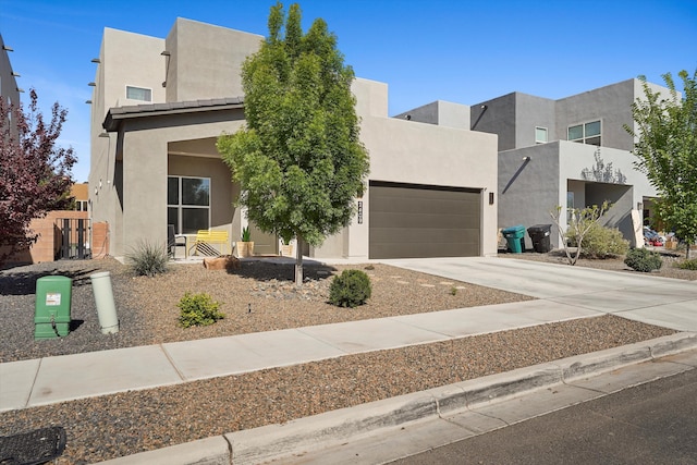 modern home featuring concrete driveway, a garage, and stucco siding