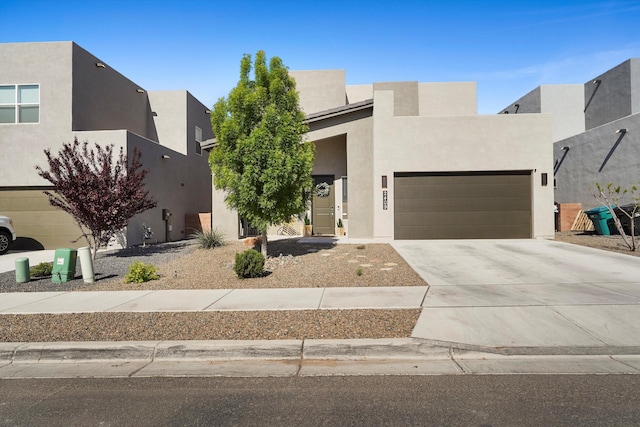 contemporary home with concrete driveway, an attached garage, and stucco siding