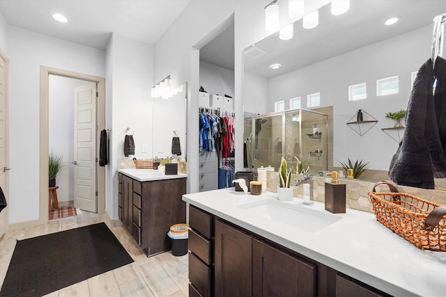 bathroom with vanity, a stall shower, recessed lighting, and a spacious closet