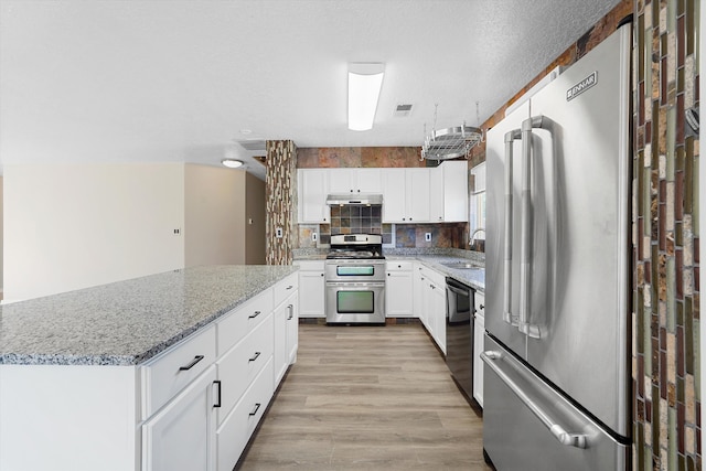 7700 Briar Ridge Ave NW, Albuquerque, NM 87114 - kitchen featuring white cabinetry, light stone counters, a sink, light wood-style flooring, and stainless steel appliances