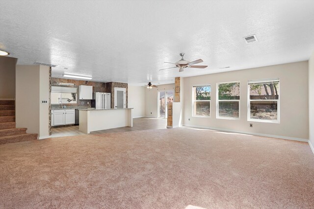 7700 Briar Ridge Ave NW, Albuquerque, NM 87114 - unfurnished living room with ceiling fan, light carpet, a textured ceiling, visible vents, and stairway