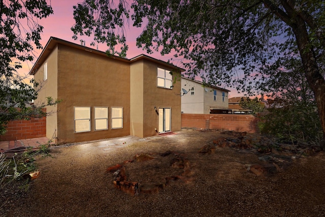 7700 Briar Ridge Ave NW, Albuquerque, NM 87114 - property exterior at dusk featuring stucco siding and fence