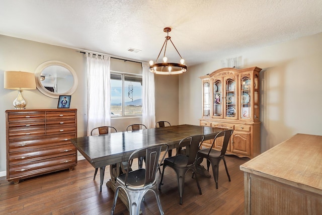 413 Afuste Rd NE, Rio Rancho, NM 87124 - dining area with an inviting chandelier, a textured ceiling, dark wood-style floors, and visible vents