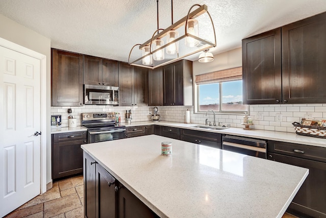 413 Afuste Rd NE, Rio Rancho, NM 87124 - kitchen featuring decorative backsplash, dark brown cabinets, a sink, hanging light fixtures, and stainless steel appliances